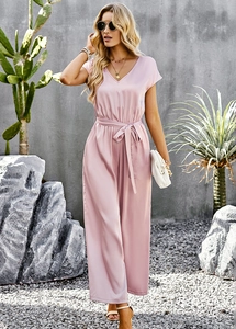 Detailed view of pink V-neck jumpsuit with waist tie and smooth satin texture finish