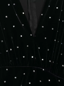Detailaufnahme des tiefen V-Ausschnitts am schwarzen Samtkleid mit silbernen Strasssteinen