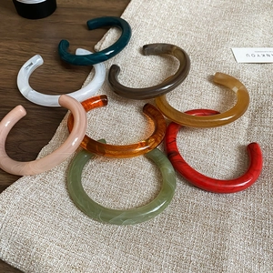 Retro resin open bangles with marble texture in various colors on a linen cloth