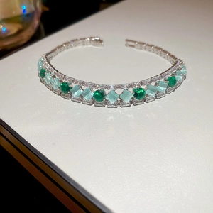 Detail of silver bracelet with green round stones and mint green square opals