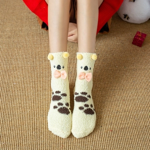 Close-up of thick yellow coral fleece socks with cute koala ears and bow details