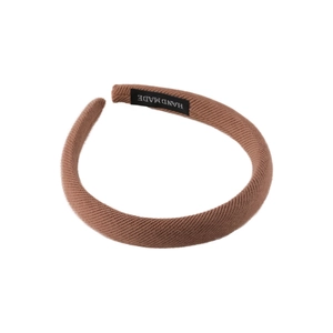 Brown padded sponge headband for high top knot look with hand made label on white background