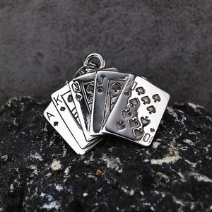 Macro shot of silver poker spade royal flush pendant on a textured dark rock