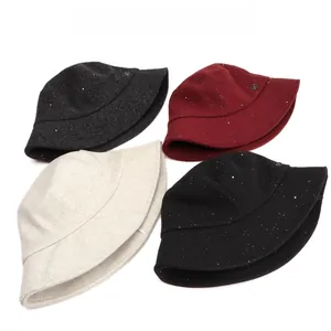 Flat lay of wool bucket hats in four colors with subtle sequins and a metal logo detail