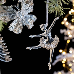 Glittery transparent acrylic Christmas butterfly and ballerina ornaments on a pine tree