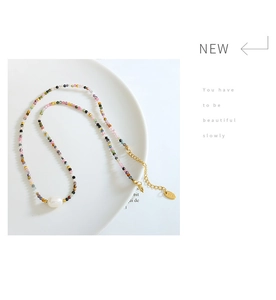 Macro detail of multi-color gemstone beads and Baroque pearl on a K18 gold-plated chain