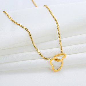 Elegant gold double-heart interlocking pendant necklace on a soft white fabric background