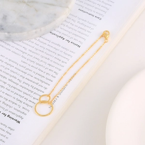 Detailed view of elegant double interlocking gold circles necklace on marble background