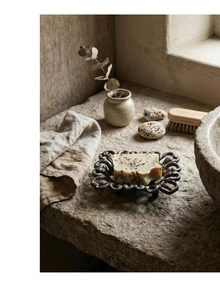 Detail of vintage cast iron soap dish with ornate carvings and natural handmade soap
