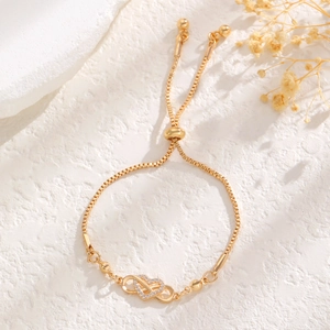 Gold adjustable bolo bracelet featuring infinity heart charms and pavé cubic zirconia