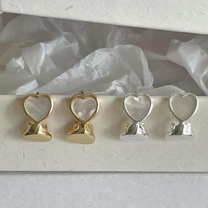 Detailed view of S925 hallmark on heart-shaped earrings with mother of pearl inlay