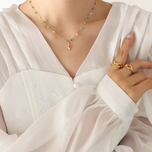 Tulip pendant necklace with green crystal beads and gold rings worn by a model