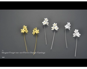 Detailed view of elegant gold and silver forget-me-not flower dangle earrings