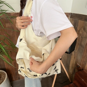Detailed view of cream canvas tote bag interior pocket and black butterfly print