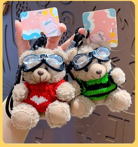 Close-up of plush bears wearing red heart and striped sweaters with cool goggles