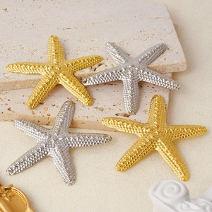 Detailed view of gold and silver starfish pendants on a marble surface for DIY jewelry