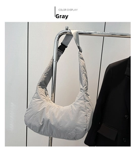 Détail du sac à bandoulière en nylon gris avec large sangle, boucle et texture matelassée