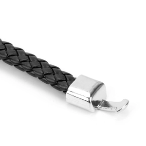 Macro shot of the black braided leather bracelet texture and silver metal clasp detail