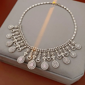 Detailed close-up of zircon flower necklace with pink pear-shaped gemstones on a stand