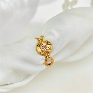 Vintage golden eight-pointed star ring with pink gemstone and twisted band on white silk