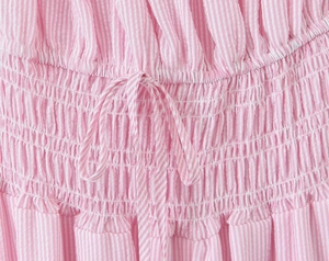 Detalle de tela a rayas rosas y blancas con textura plisada y nudo decorativo fino