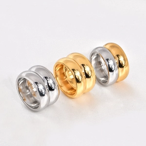 Macro shot of polished wide dome rings in gold and silver finishes on white fabric