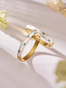 Detail of 18k gold plated bangle with white enamel and turquoise evil eye charms