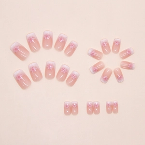 Pink gradient French press-on nails with delicate cherry blossom designs and fine glitters