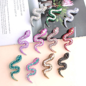 Detailed close-up showing a colorful collection of snake brooches with sparkling crystals