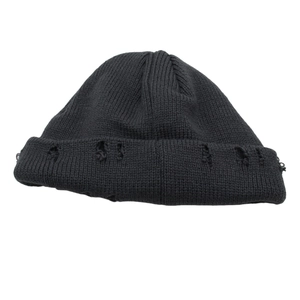 Dettaglio di un berretto nero in maglia invecchiata con strappi trendy in stile hip-hop