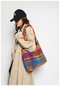 Detail of colorful plaid plush tote bag texture with logo patch and wide strap