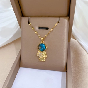 Detailed close-up of golden astronaut pendant with blue starry gem and sparkling star