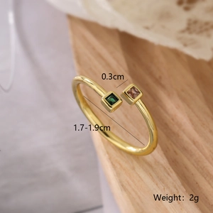 Macro detail of gold plated geometric ring with emerald and pink stones and measurements