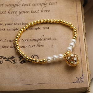 Détail d'un bracelet perlé avec billes en métal doré, perles et un pendentif étoile