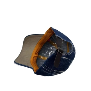 Detail of denim baseball cap with leather strap and adjustable metal buckle