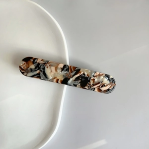 Detail of amber tortoiseshell hair clip with delicate golden bead flower patterns