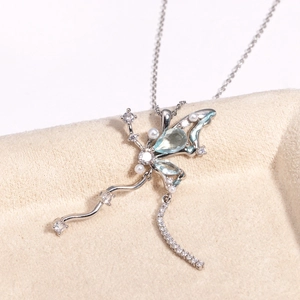 Détail du pendentif papillon argenté avec pierres bleues et zircons étincelants
