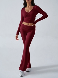 Detail of burgundy two-piece sports set with V-neck long sleeve top and flared knit pants