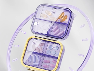 Detail of an 8-compartment pill organizer in purple and yellow with clock graphic
