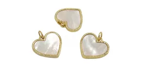 Macro detail of heart-shaped shell pendants with gold beaded edges for DIY jewelry