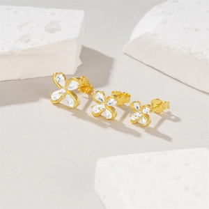 Detailed comparison of three sizes of gold clover stud earrings with white zircons