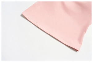 Dettaglio ravvicinato della doppia cucitura piatta sul tessuto elastico del top yoga rosa