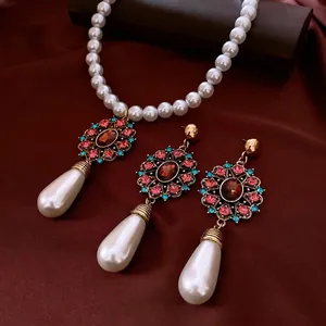 Vintage jewelry set with pearl necklace and teardrop earrings on red silk background
