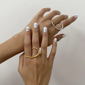 Polished gold and silver minimalist fluid curve rings worn on fingers with metallic nails