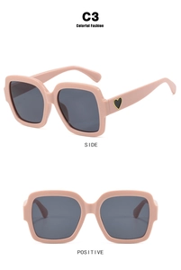 Detailansicht der rosa quadratischen Oversize-Sonnenbrille mit Herzdekor und Seitenprofil