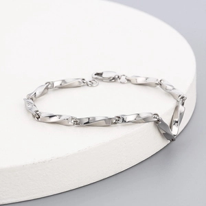 Détail du bracelet chaîne à maillons torsadés Mobius argent sur socle blanc géométrique