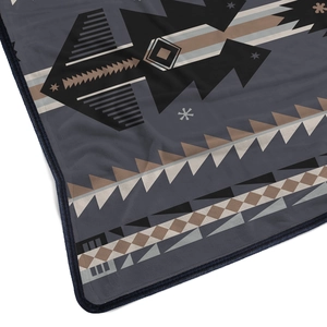 Macro detail of soft flannel blanket featuring ethnic geometric patterns and fine stitching