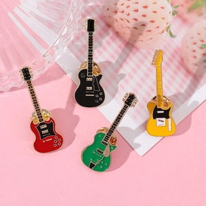 Detailed close-up of four colorful electric guitar enamel pins on a pink decorative background