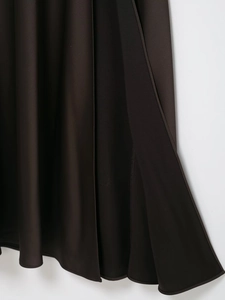 Detailed view of dark brown satin dress hem featuring smooth texture and quality stitching