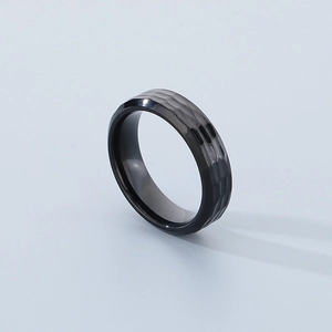 Macro detail of men's black titanium ring with hammered texture and metallic finish